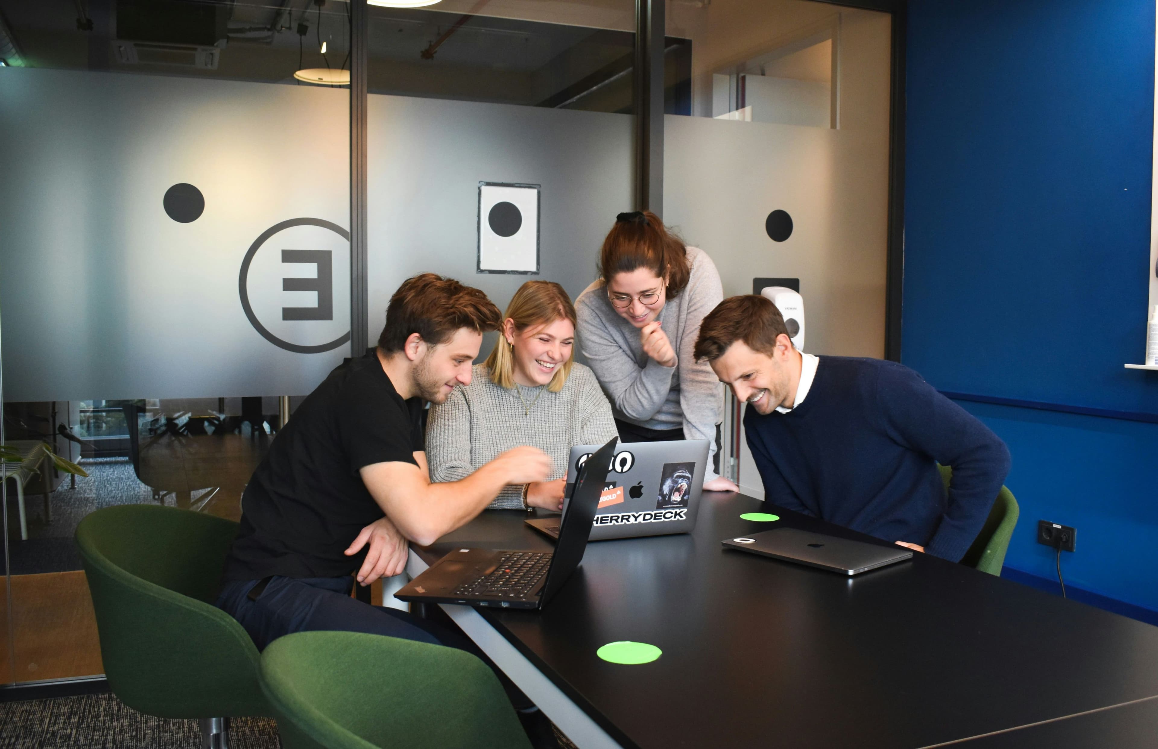 Team collaborating around a laptop